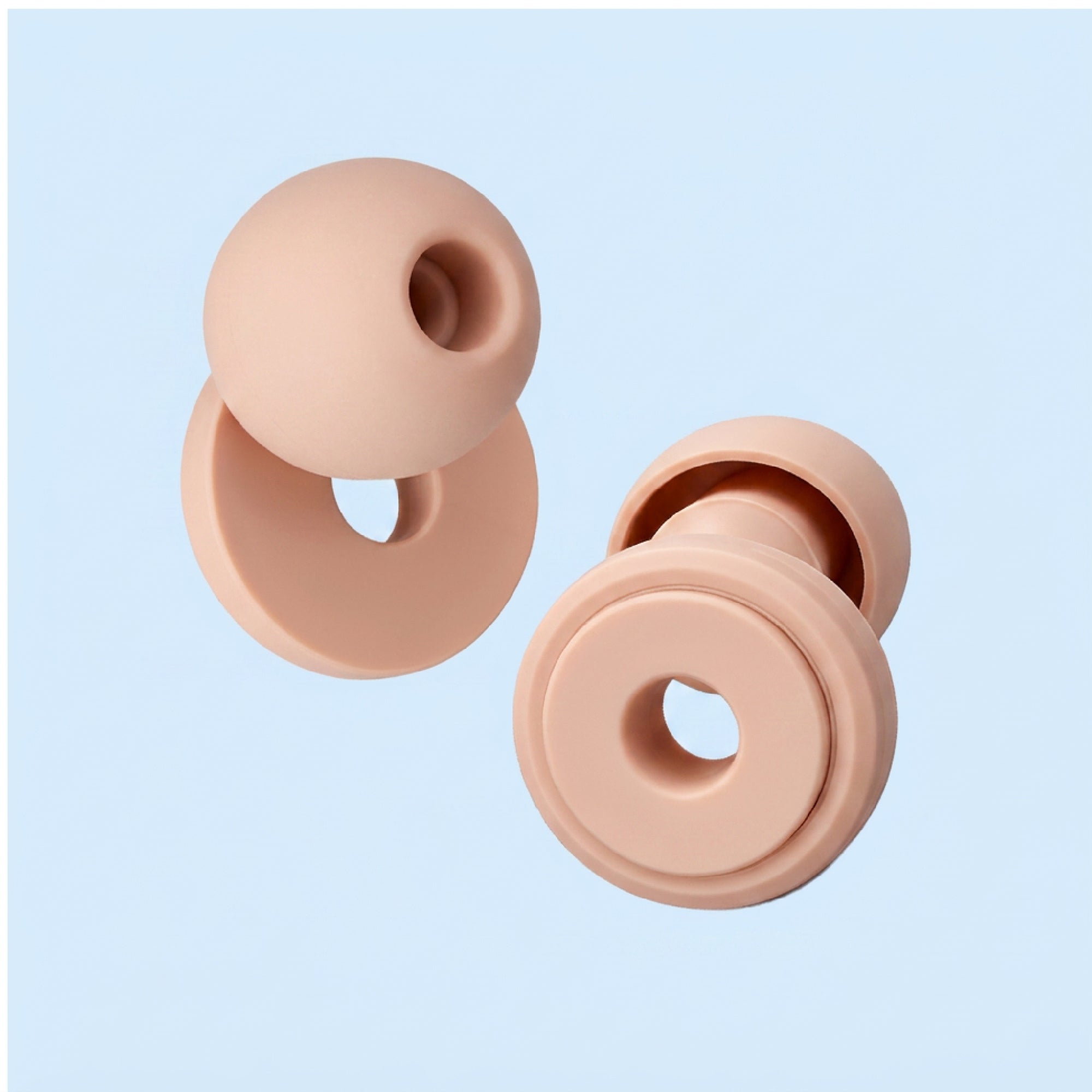 Two beige silicone donut-shaped objects on a light blue background