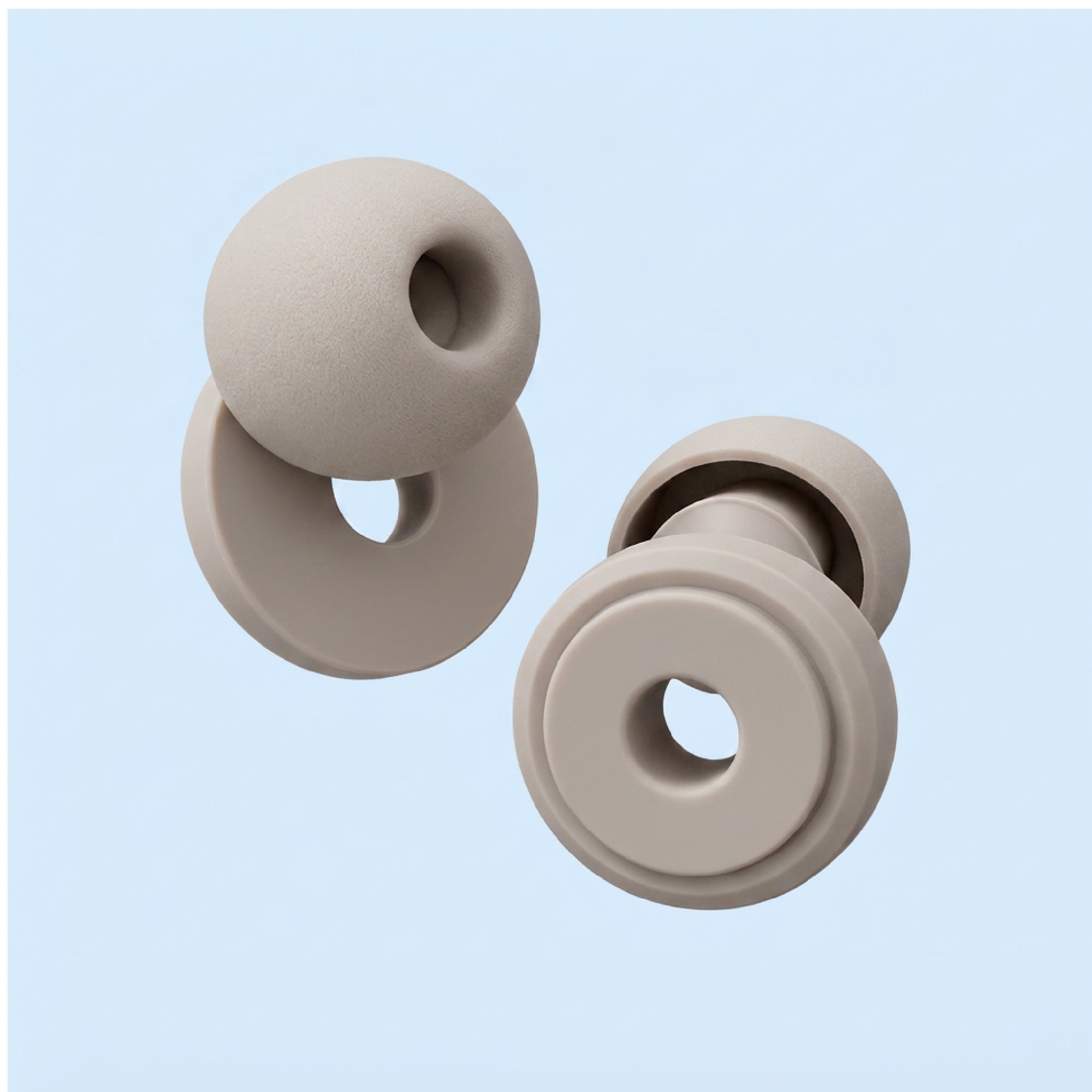 Two beige silicone donut-shaped chew toys on a light blue background